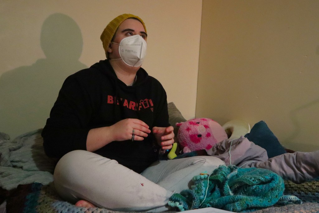 Aspen sat looking up, hands moving as they speak.