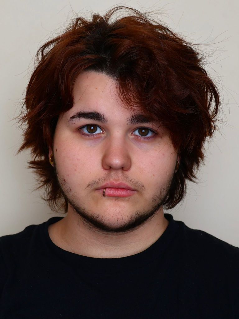 Evan, a white masc person with dark red hair and a lip ring.