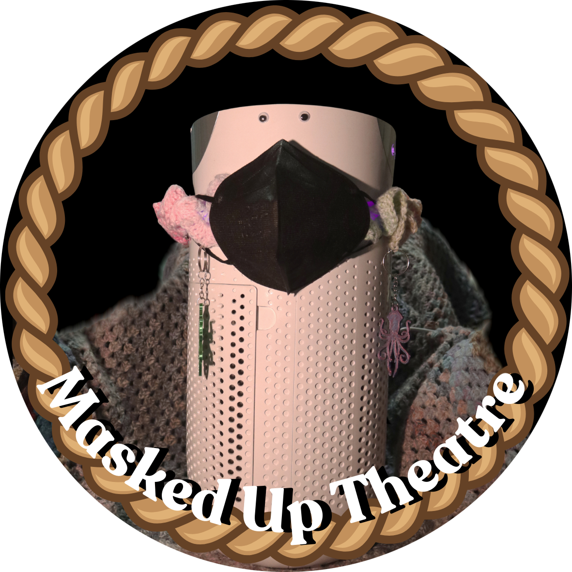 An air purifier with a face mask, googly eyes and a clown collar. Captioned Masked Up Theatre